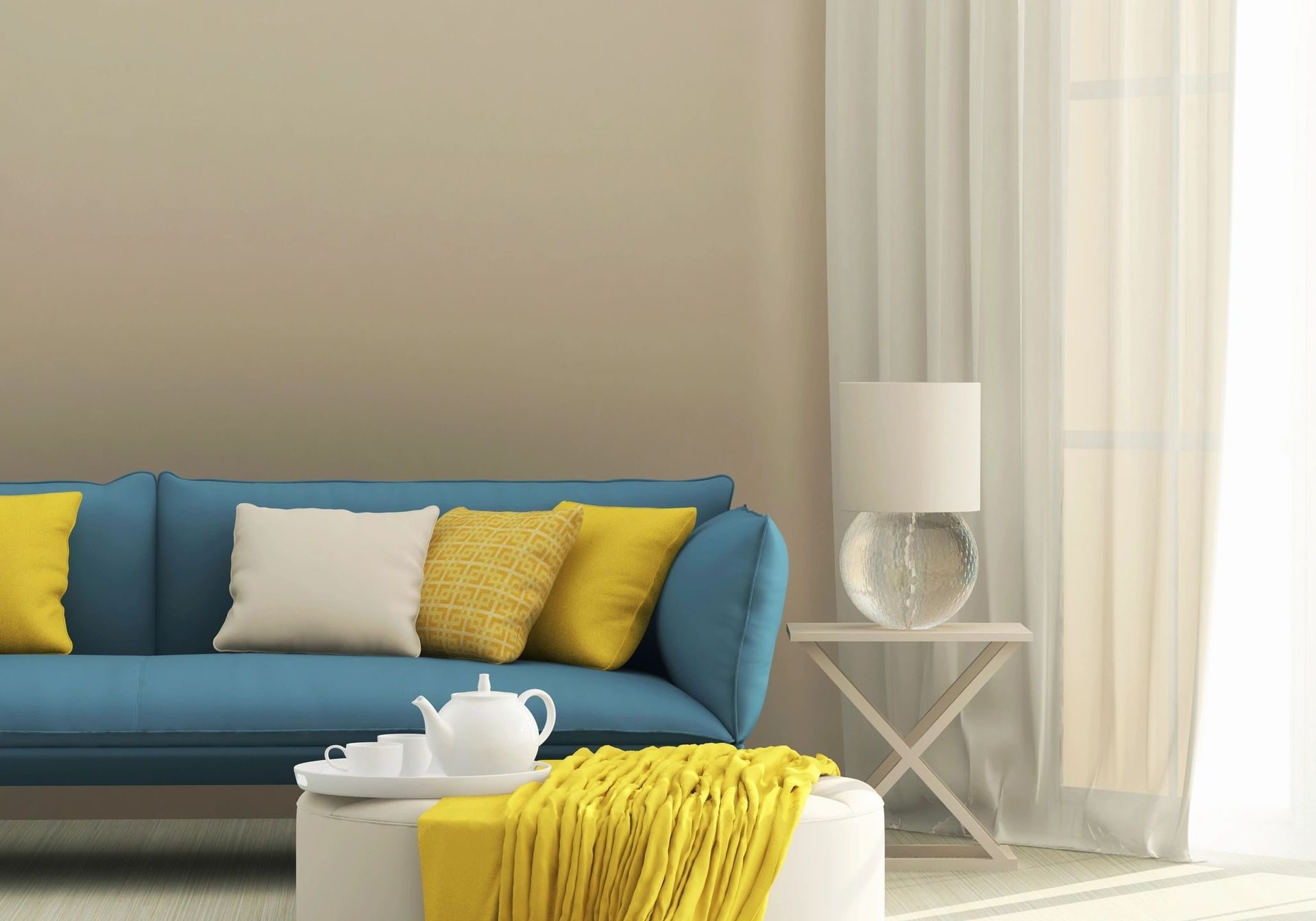 A living room with a blue couch and yellow pillows.