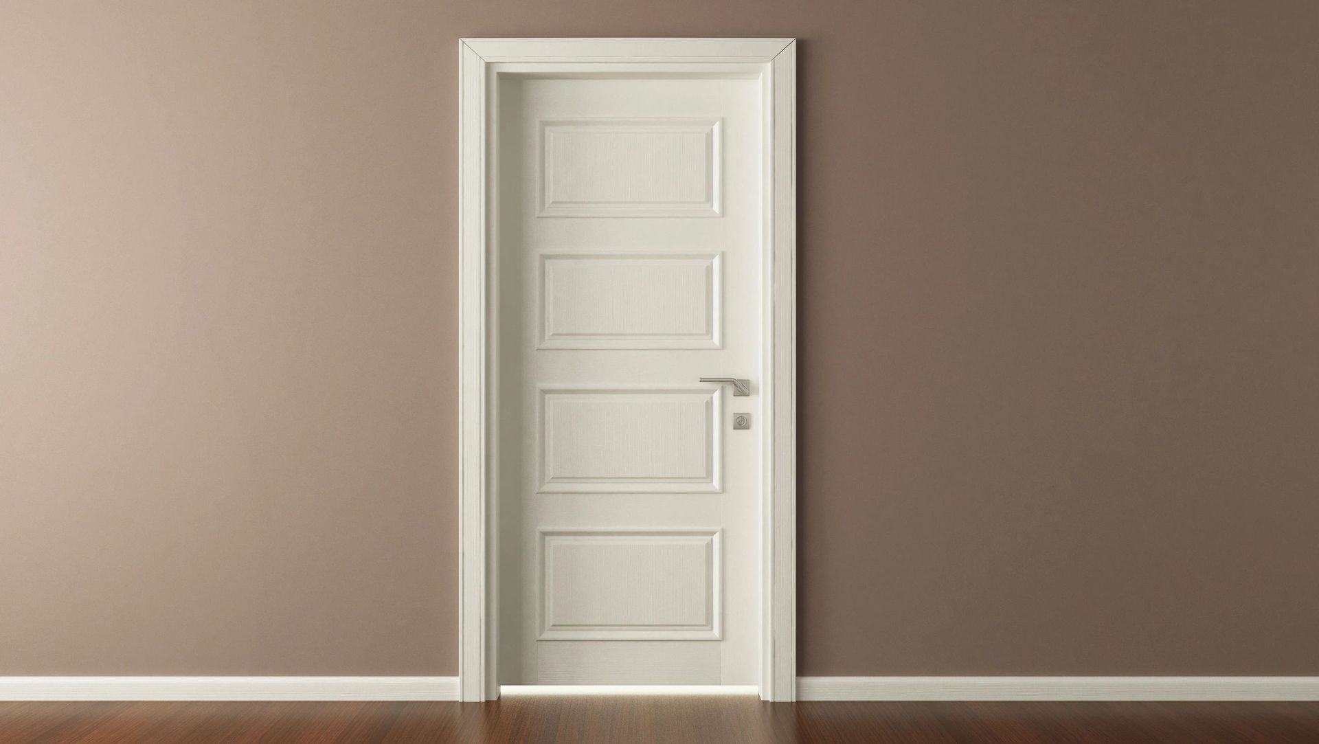 An empty room with a white door and brown walls.