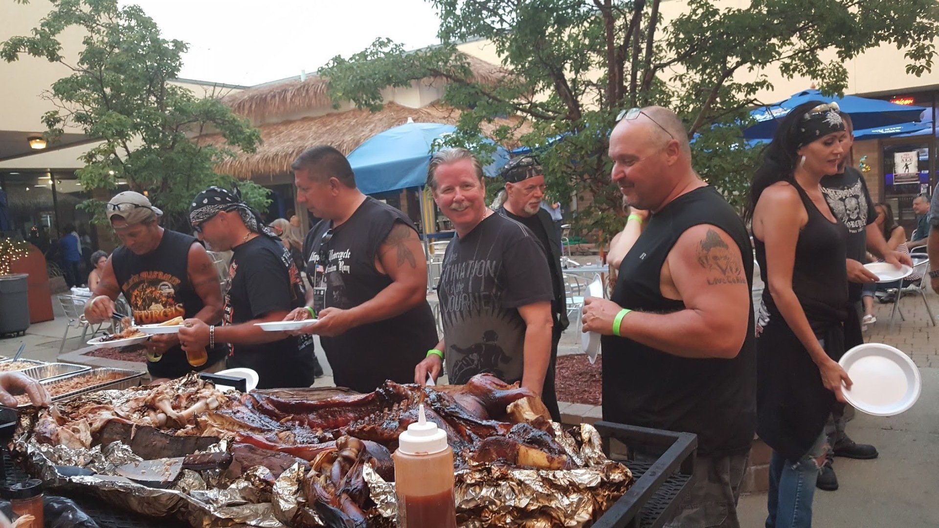 A group of people are standing around a table of food.