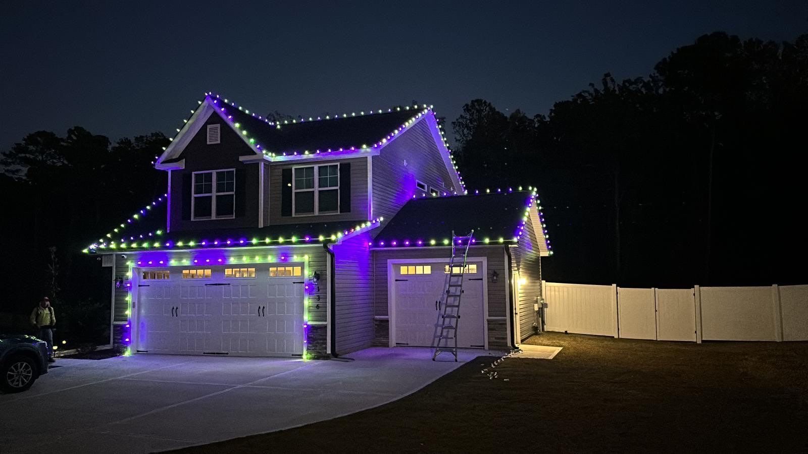 A house is decorated with christmas lights at night.