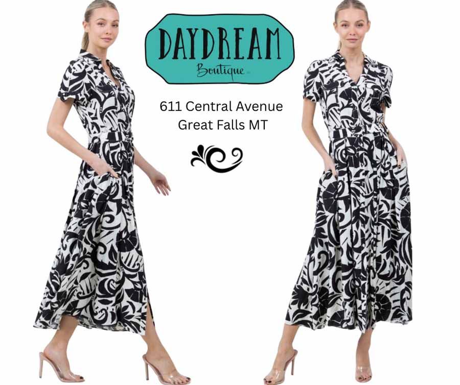Woman in black and white print dress, posing. Daydream Boutique logo above, location below.