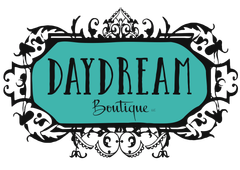 Daydream Boutique logo in black script on a teal background, framed by decorative black swirls.