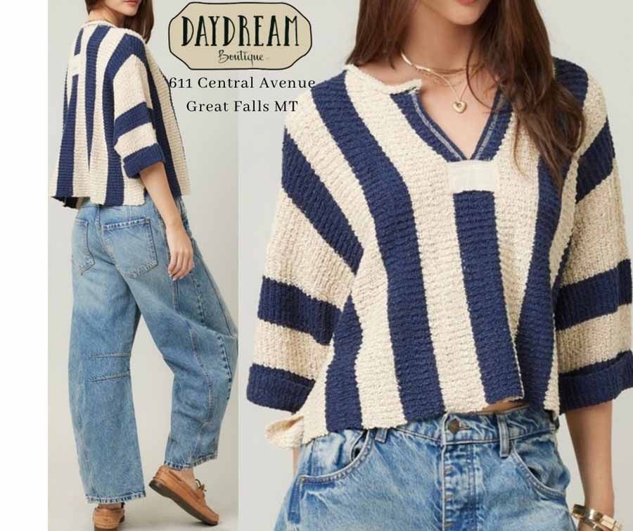 Woman in blue and cream striped crop top and jeans.