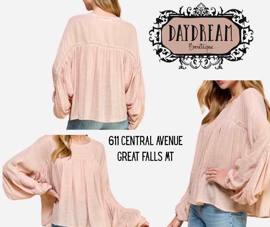 Woman wearing a pink blouse from Daydream Boutique, with store logo and address.