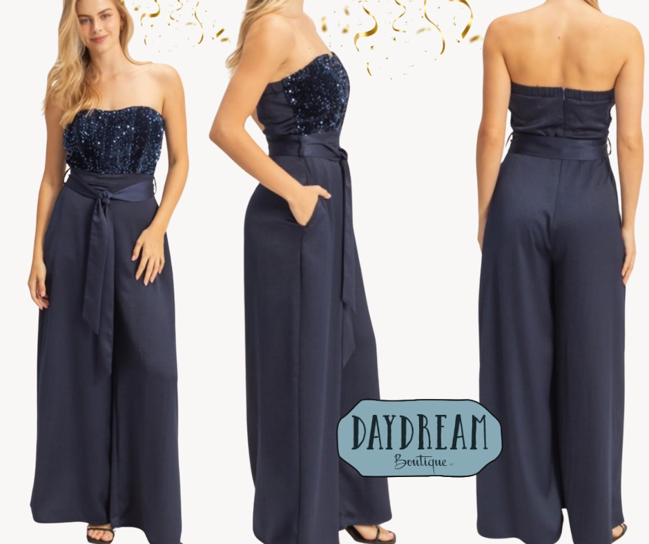 Navy sequin bodice jumpsuit with tie waist and wide legs.