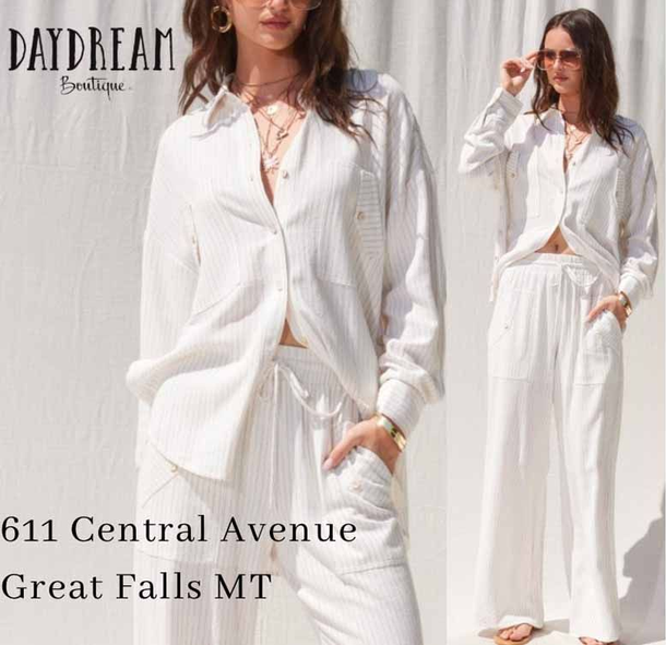 Woman wearing a white, striped outfit from Daydream Boutique, posing in front of a white backdrop.