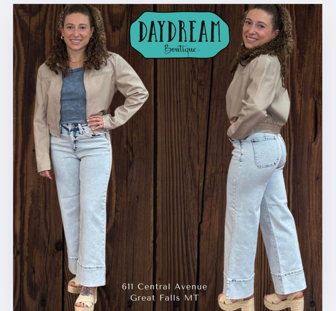 Woman in jeans and jacket poses in front of a wood background. 