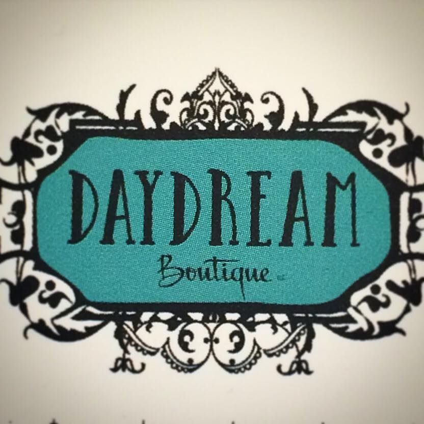 Logo for Daydream Boutique: turquoise text on black and white filigree.