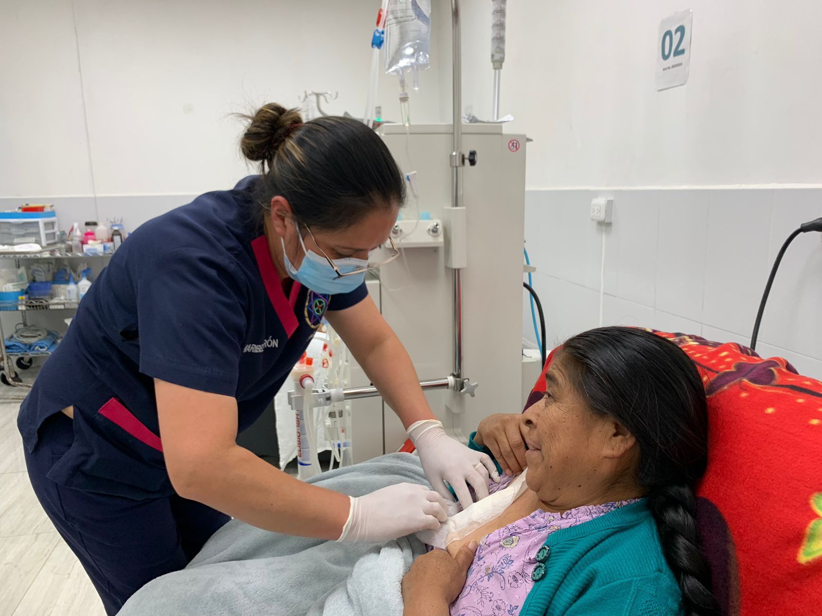 Eine Krankenschwester kümmert sich in einem Krankenzimmer um einen Patienten. 