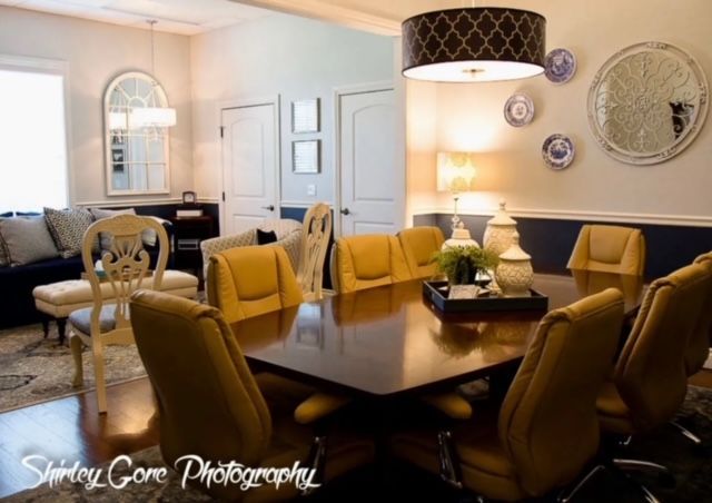 A conference room with a table and chairs and plates on the wall