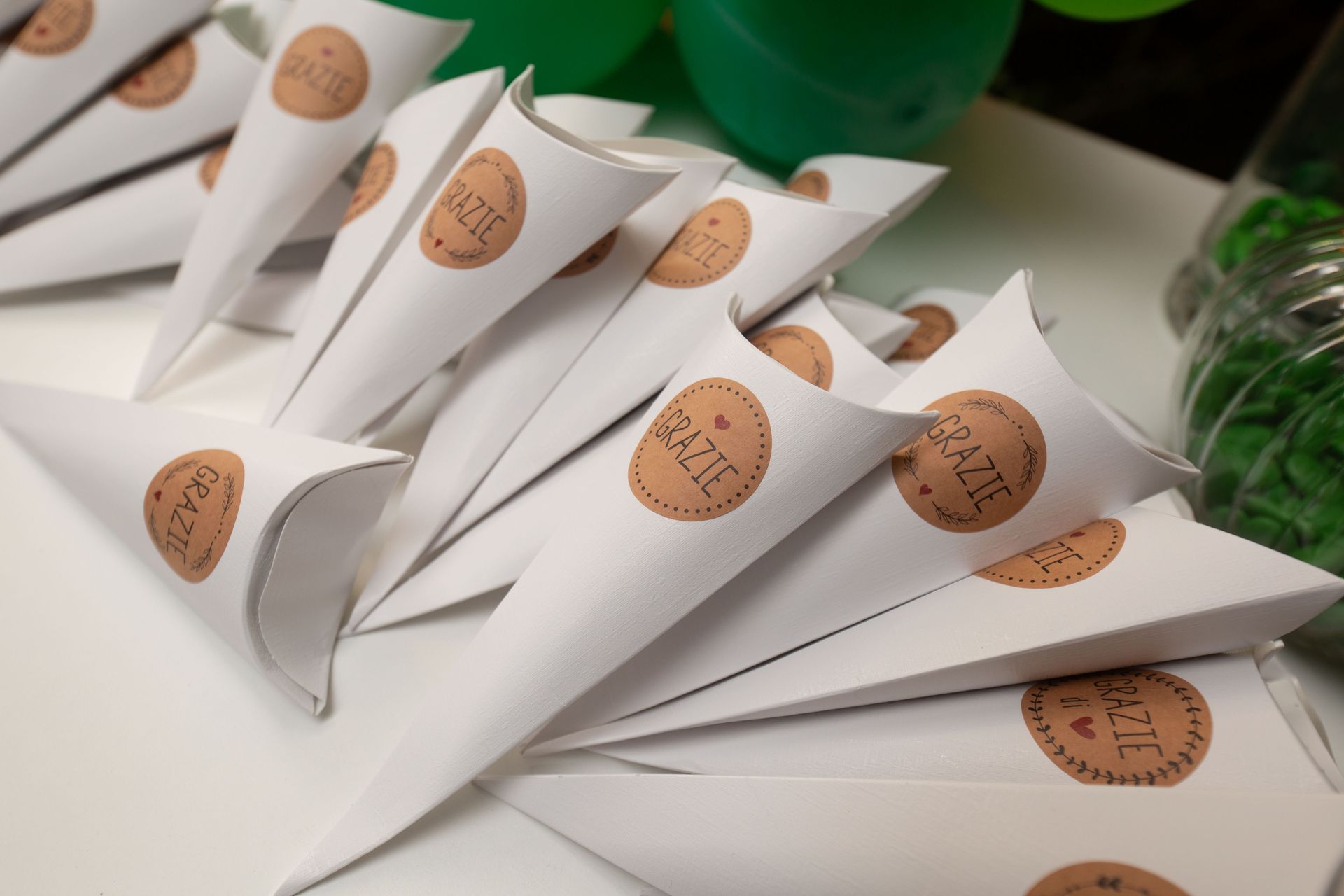 Su un tavolo ci sono dei coni di carta bianchi con la scritta 