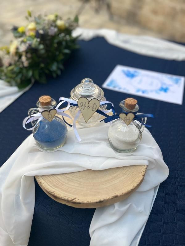 Una coppia si abbraccia in uno spazio rustico e scarsamente illuminato da lucine. La donna indossa un abito da sposa bianco.