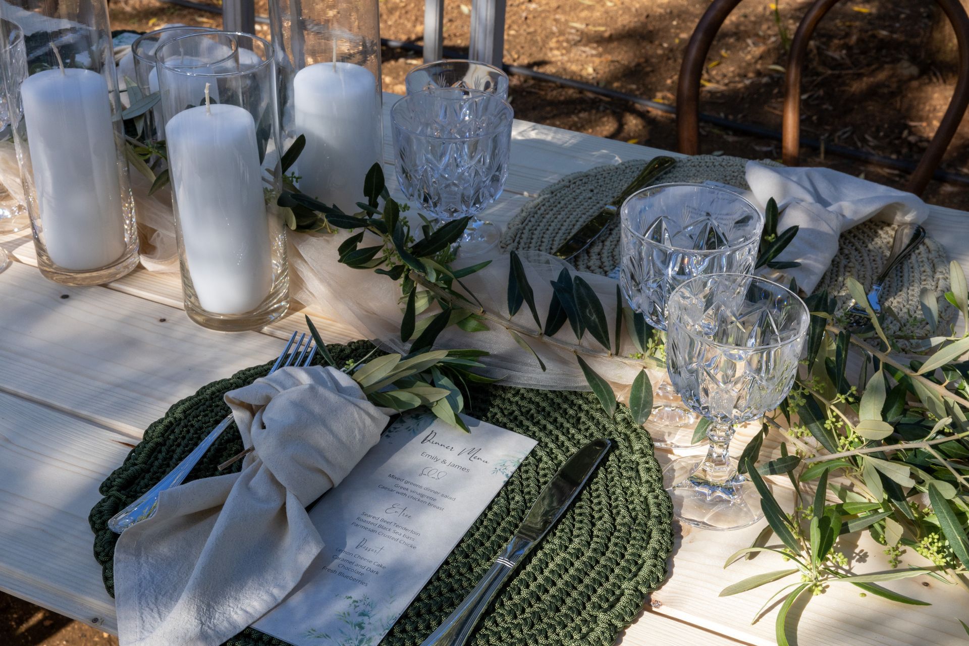 Apparecchiatura del tavolo nuziale con candele, verde, bicchieri di cristallo e tovaglietta intrecciata.