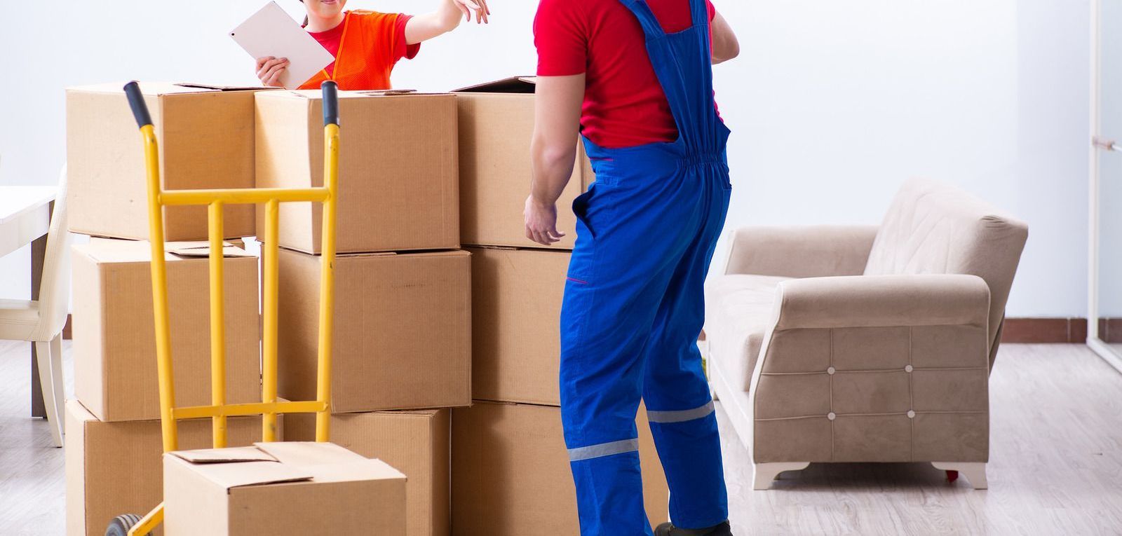 A man is standing next to a stack of cardboard boxes in a living room.