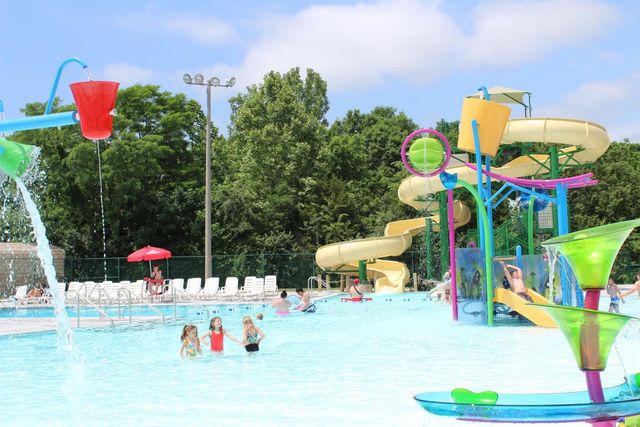 A group of people are playing in a water park with a water slide.
