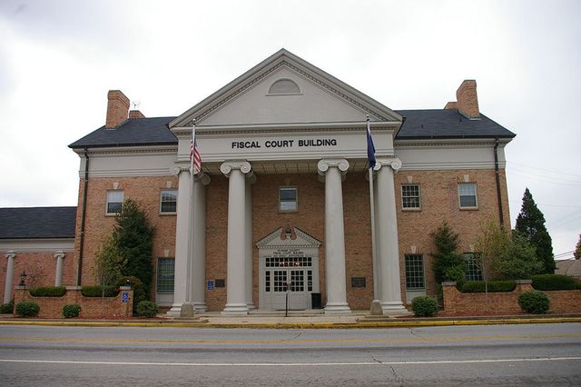 A brick building with columns and a sign that says fiscal court building