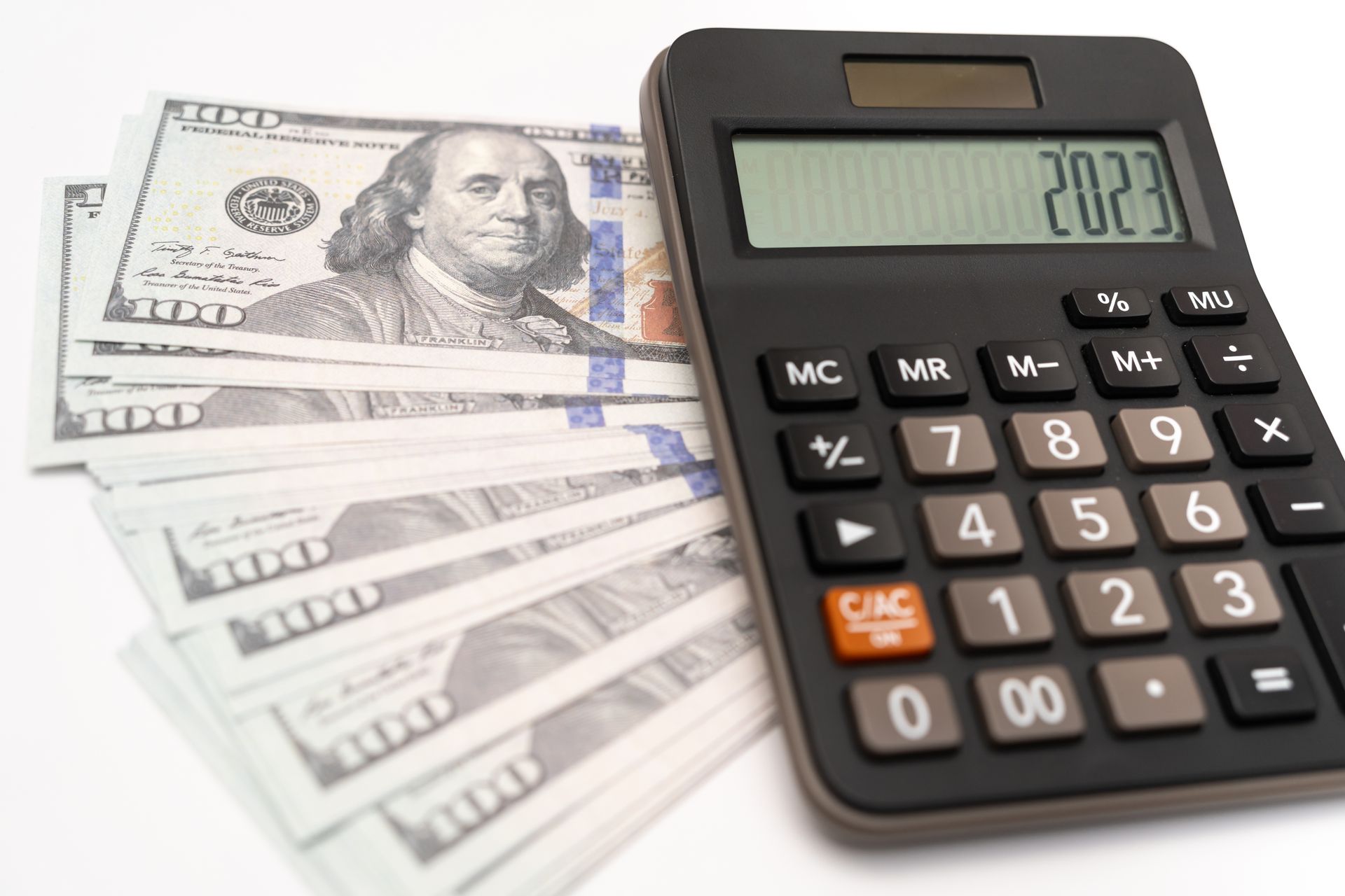 A calculator is sitting on top of a pile of money