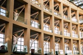 Interior of a modern wooden building with large windows and open balconies