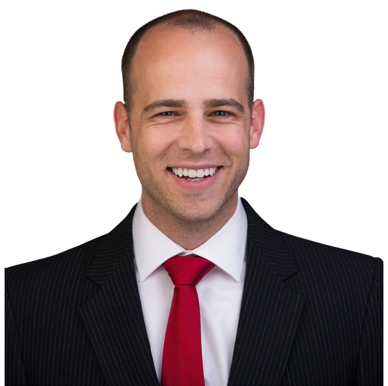 Man in suit, smiling, red tie, bald head.