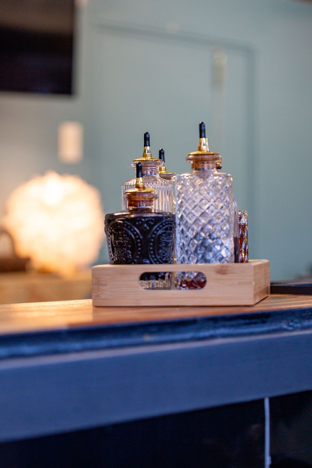 A wooden tray with bottles on it is on a table.