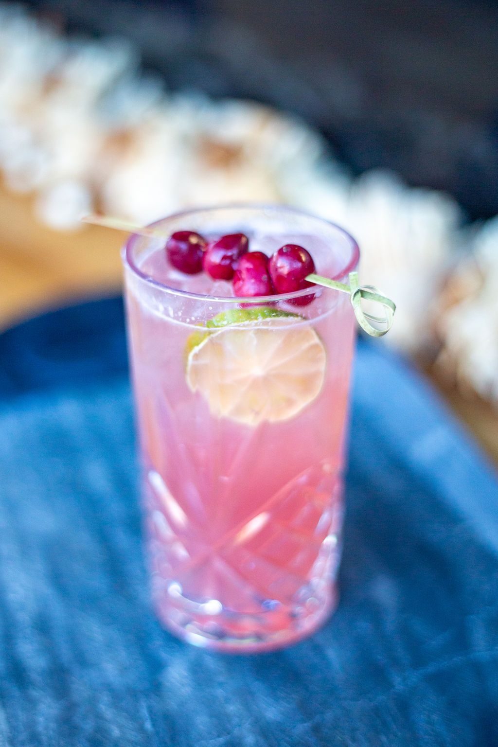 A close up of a pink drink in a glass on a table.
