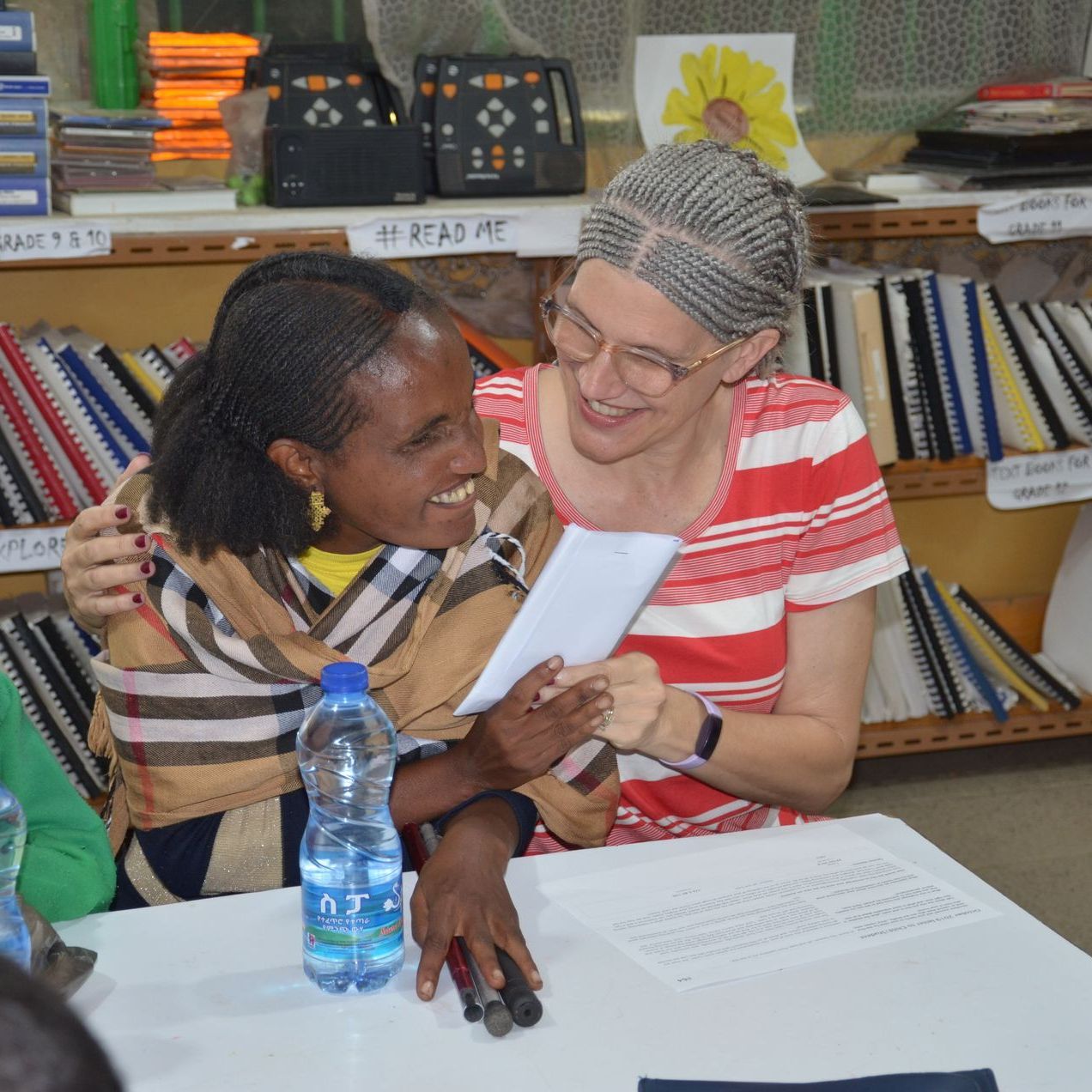 Fields of Promise director helping a blind student with school work