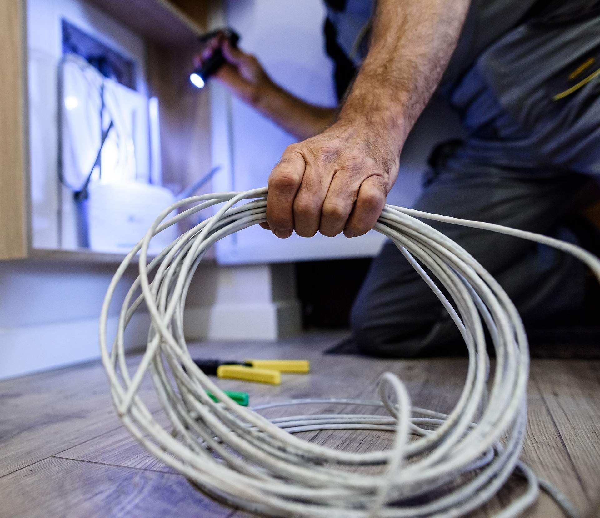 a man is holding a roll of wire in his hand .