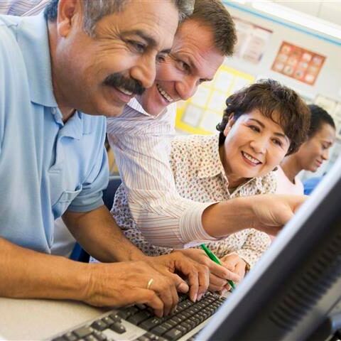A group of people are looking at a computer screen together