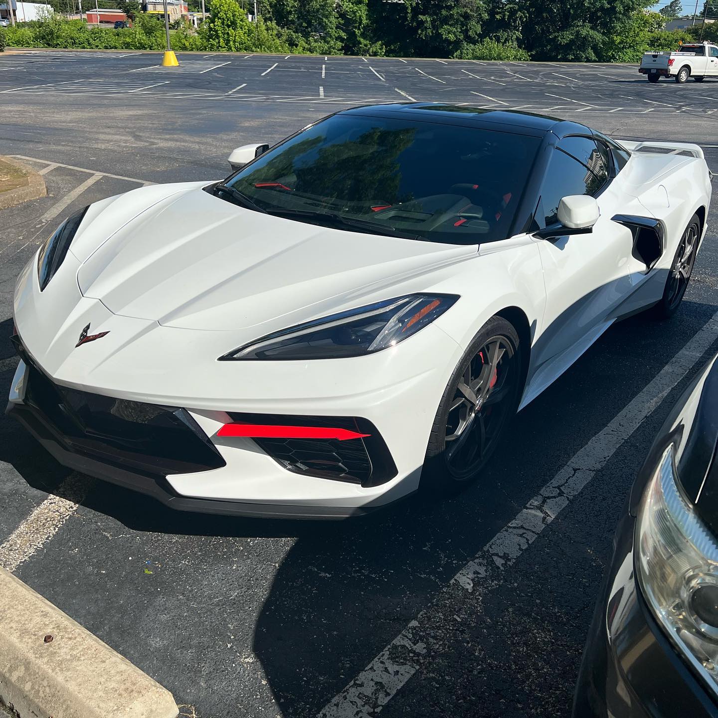 C8 Corvette with a custom wrap featuring red accents on the front and a black top wrap