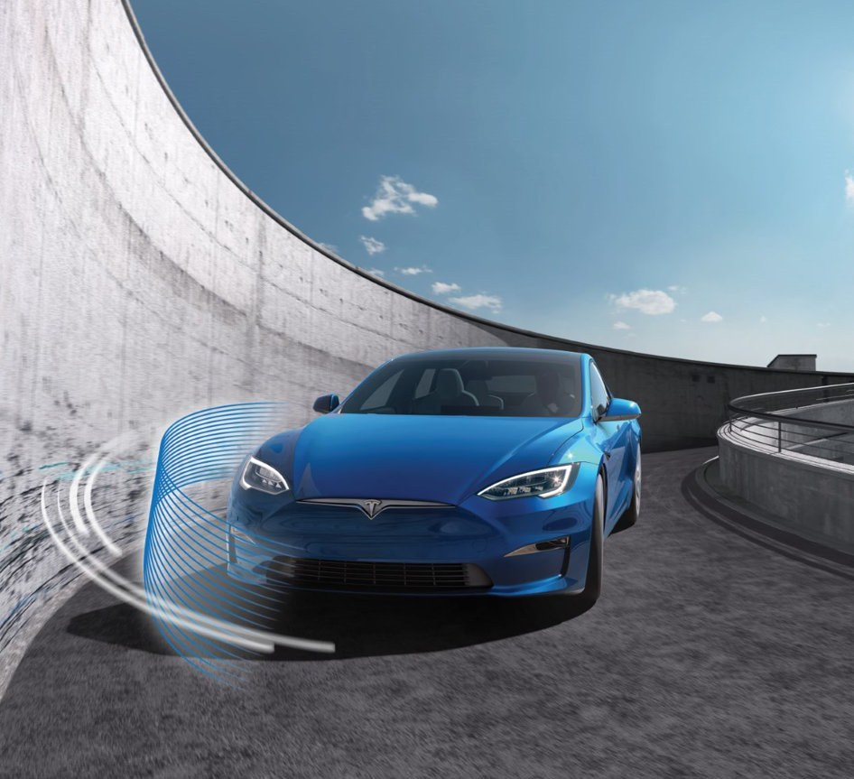 A blue Tesla is driving down a parking garage roundabout ramp