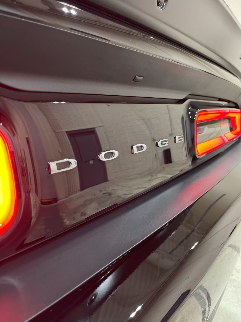 Close-up view of the back of a Dodge car with a glossy, shiny finish showcasing the effects of ceramic coating.