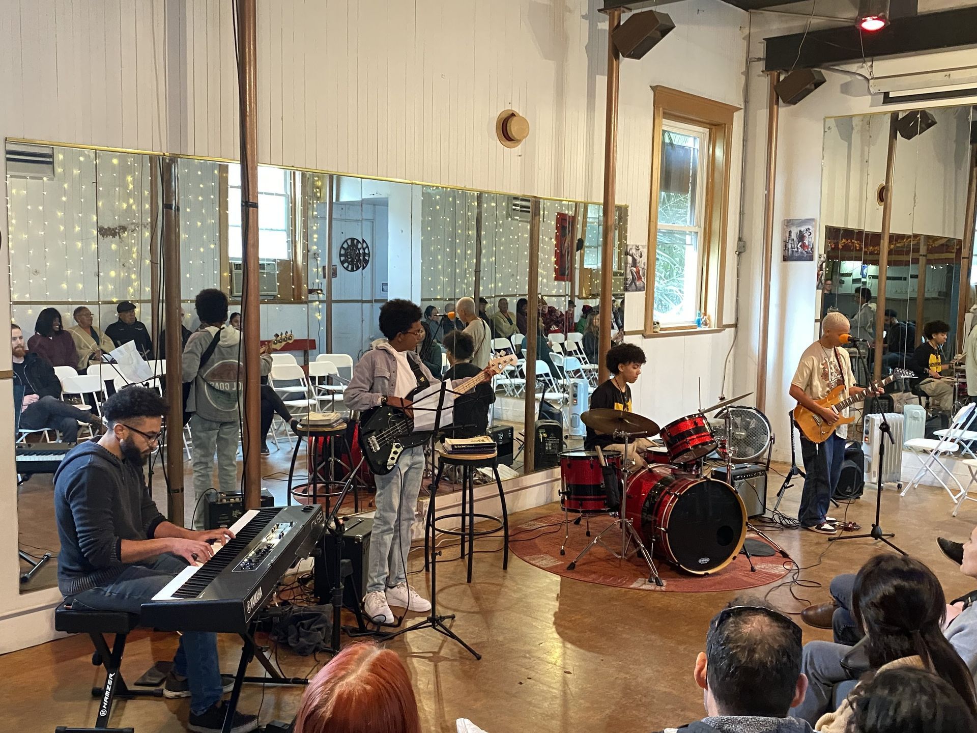 A group of people are sitting in a room playing instruments.