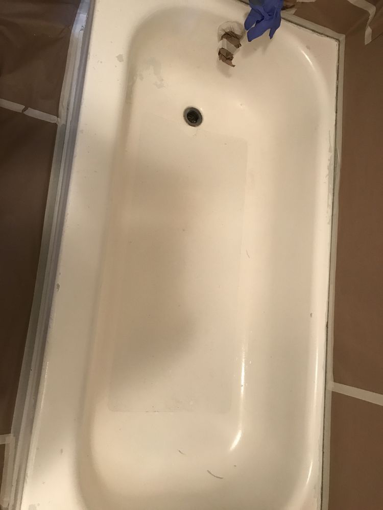 White bathtub with a drain and faucet, marked by a blue tape or cloth near the spout.