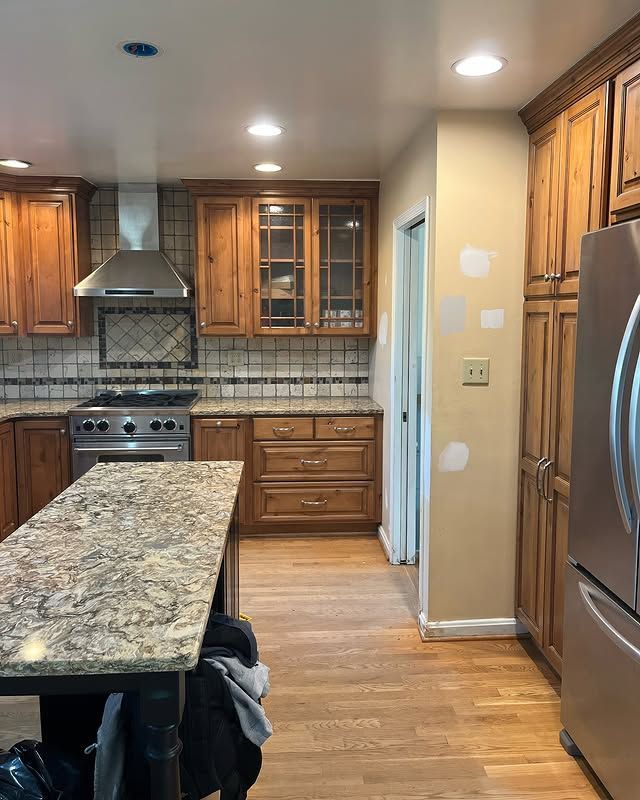 Gray kitchen with black oven, white microwave, and stainless steel sink.
