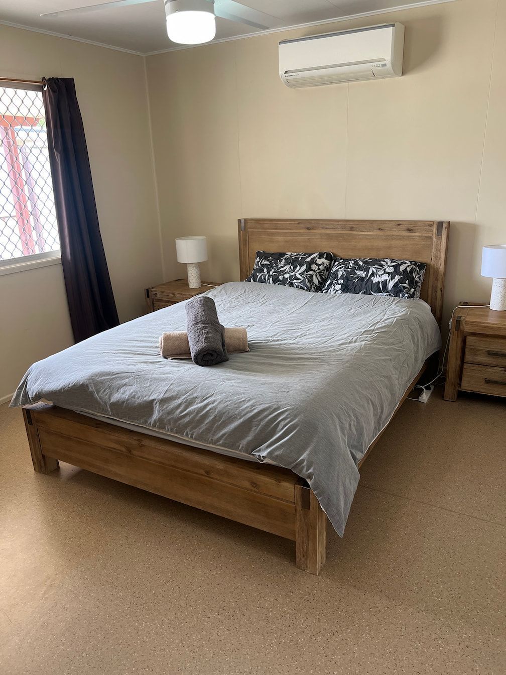 A Bedroom With A Bed , Two Nightstands , Two Lamps And A Window — Miss Bright Cleaning Services In Mount Isa City, QLD