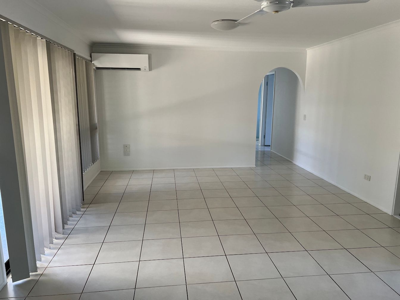 An Empty Living Room With White Tile Floors And A Ceiling Fan — Miss Bright Cleaning Services In Mount Isa City, QLD