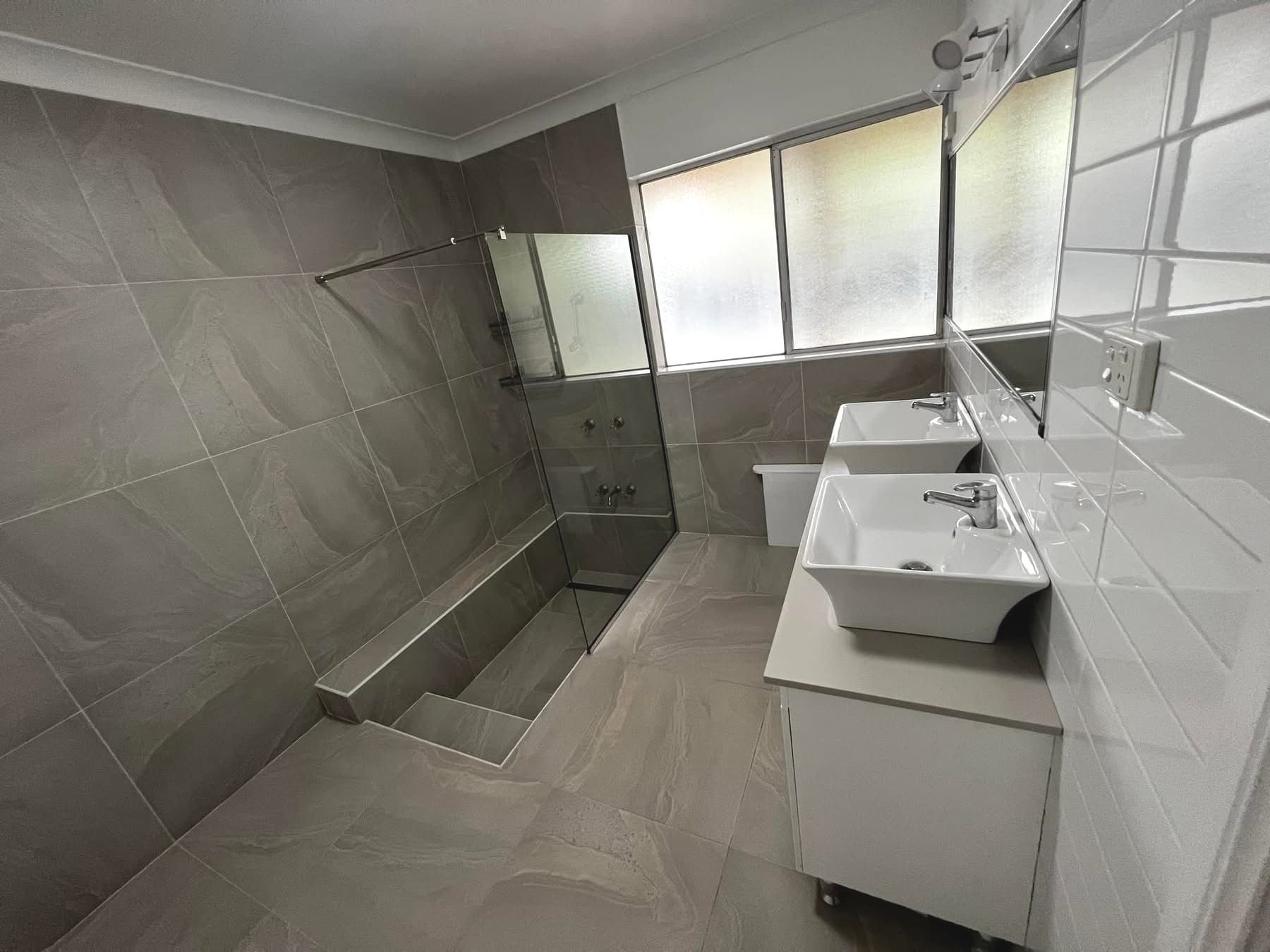 A Man is Spraying Insecticide on a Wooden Staircase — Miss Bright Cleaning Services In Mount Isa City, QLD A Man is Spraying Insecticide on a Wooden Staircase — Miss Bright Cleaning Services In Mount Isa City, QLD