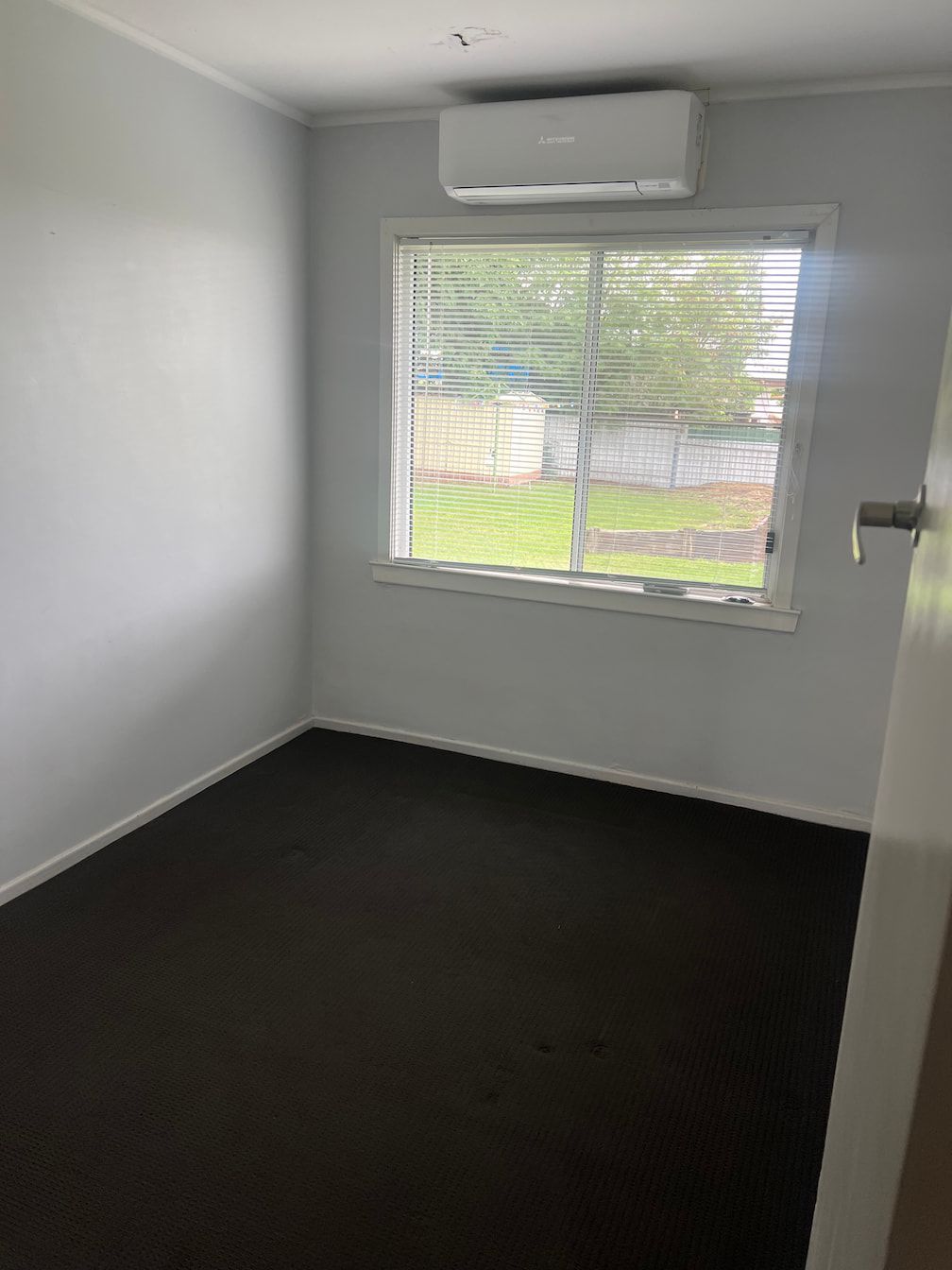 A Person Wearing Pink Gloves is Cleaning a Carpet With a Vacuum Cleaner — Miss Bright Cleaning Services In Mount Isa City, QLD A Person Cleaning a Carpet With a Vacuum Cleaner — Miss Bright Cleaning Services In Mount Isa City, QLD