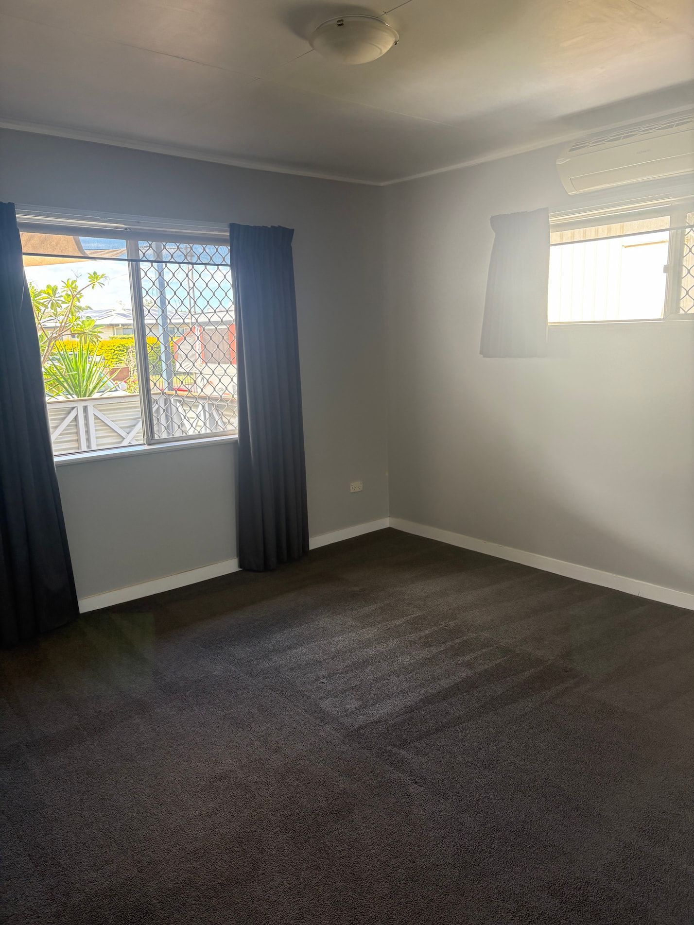 An Empty Room With A Carpeted Floor And A Window — Miss Bright Cleaning Services In Mount Isa City, QLD