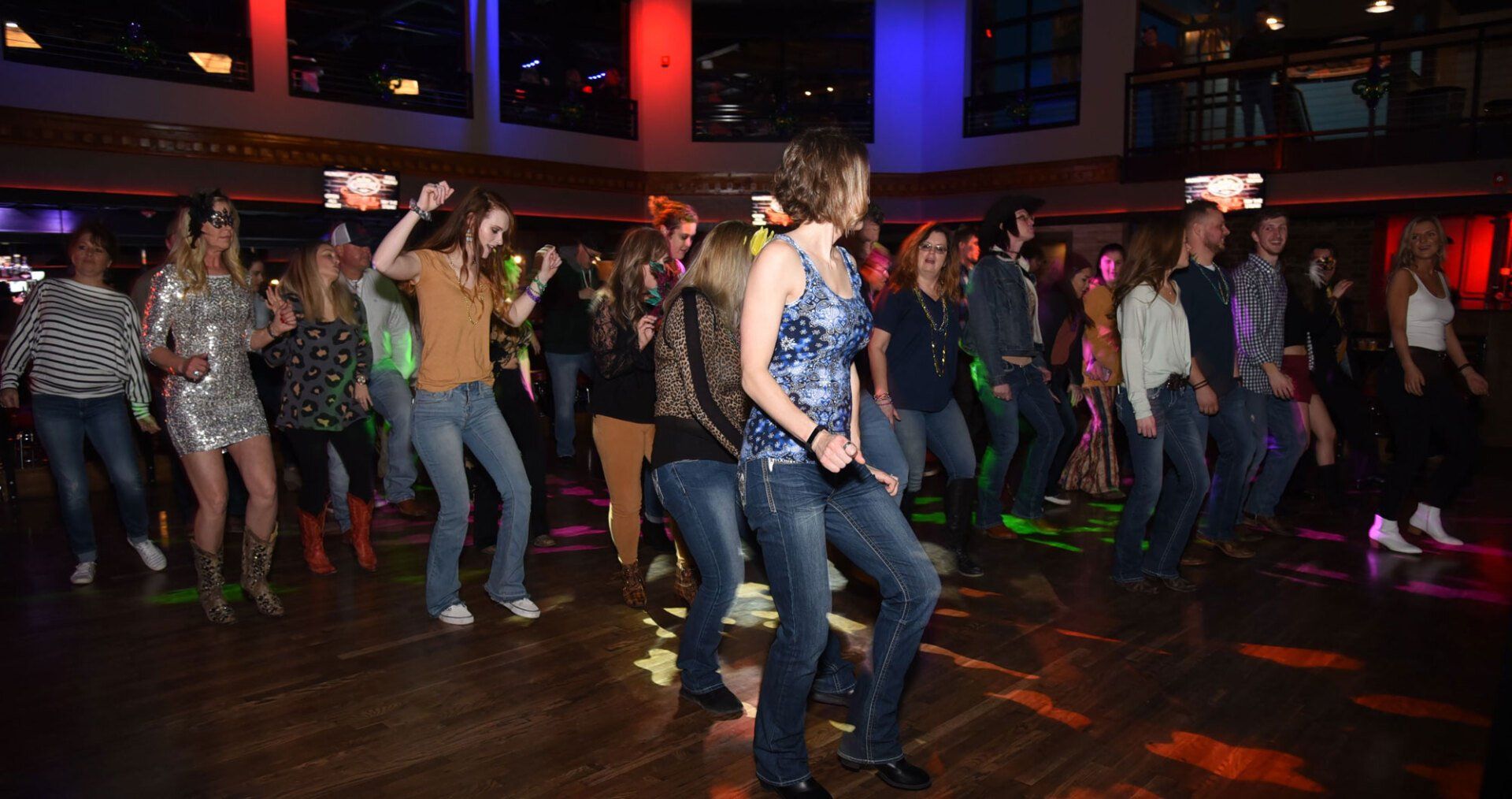 people line dancing at a country bar
