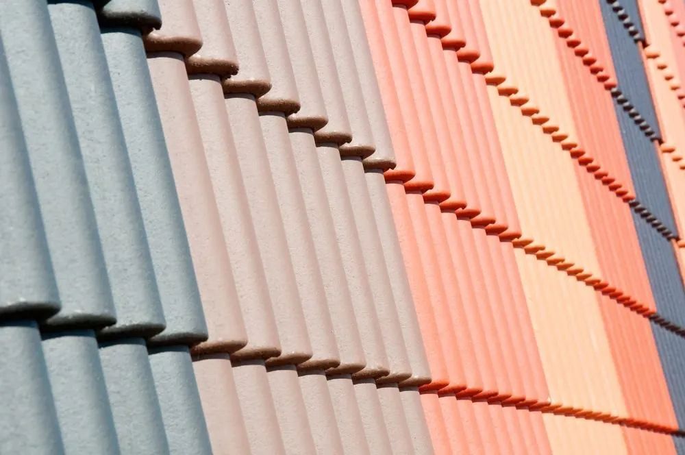 Close-up of a colourful wall with vertical ceramic tiles in shades of blue, grey, and terracotta.
