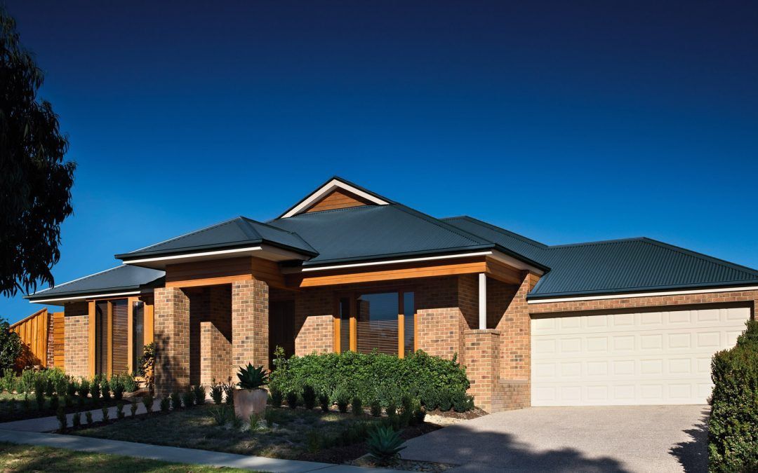 A Brick House With a Black Roof and a White Garage Door — Ron Nickel Roofing in Tweed Heads South, NSW