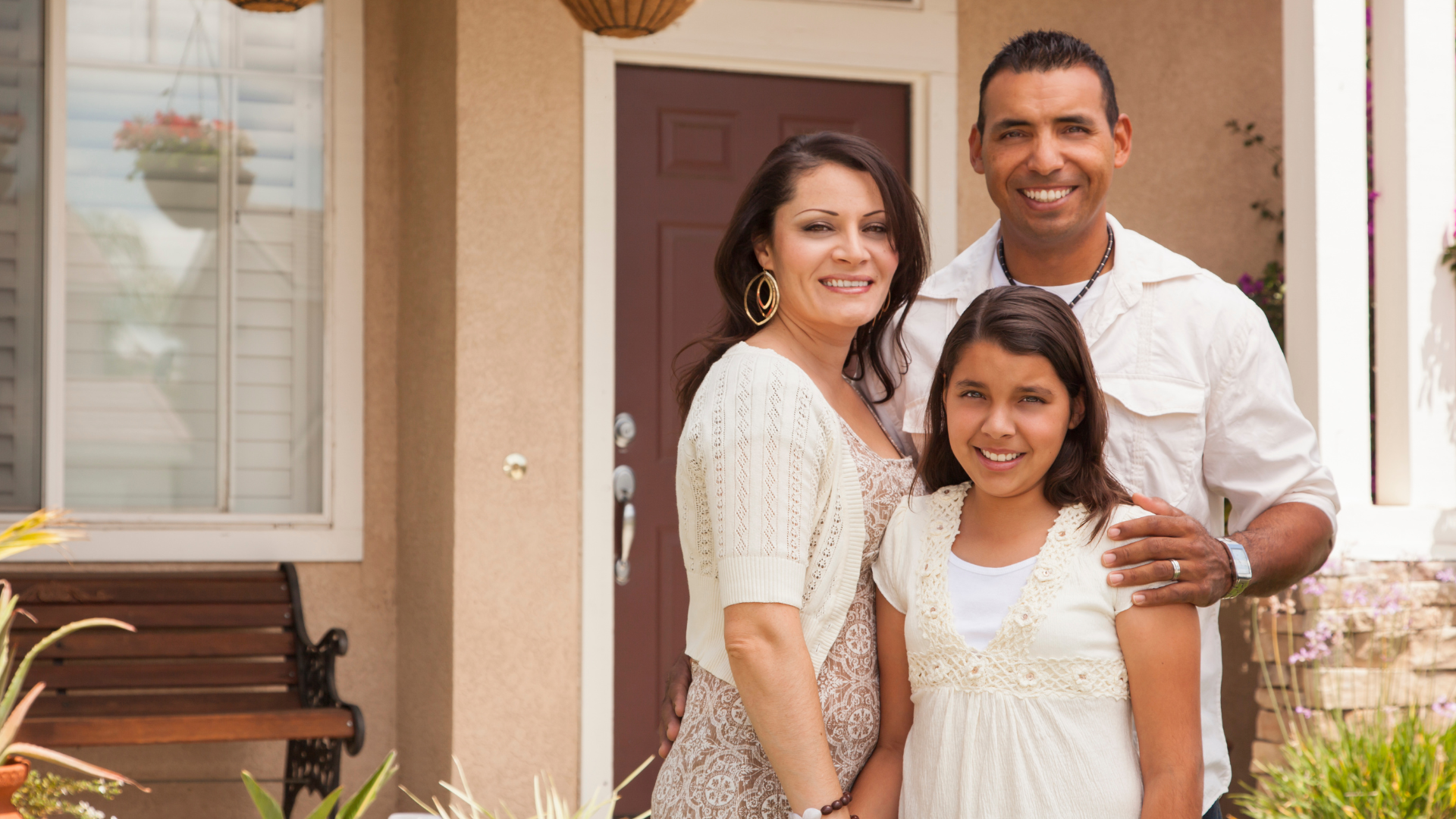 A family is posing for a picture in front of their house.