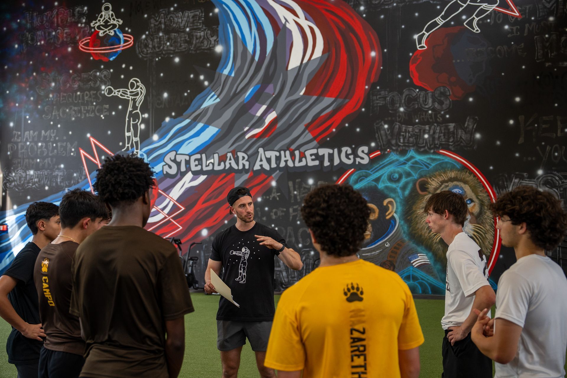 A group of young people are posing for a picture in a gym.