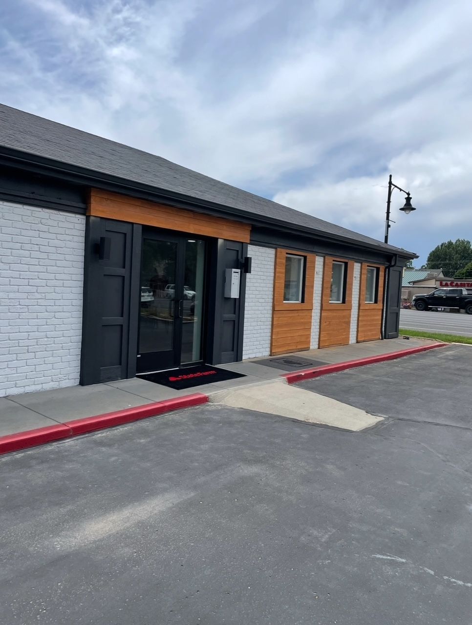 Exterior of a building with brick and wood siding; accessible ramp to the entrance.