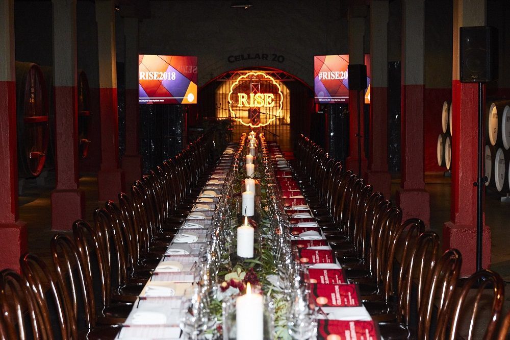 A long table with a sign that says rise in the background