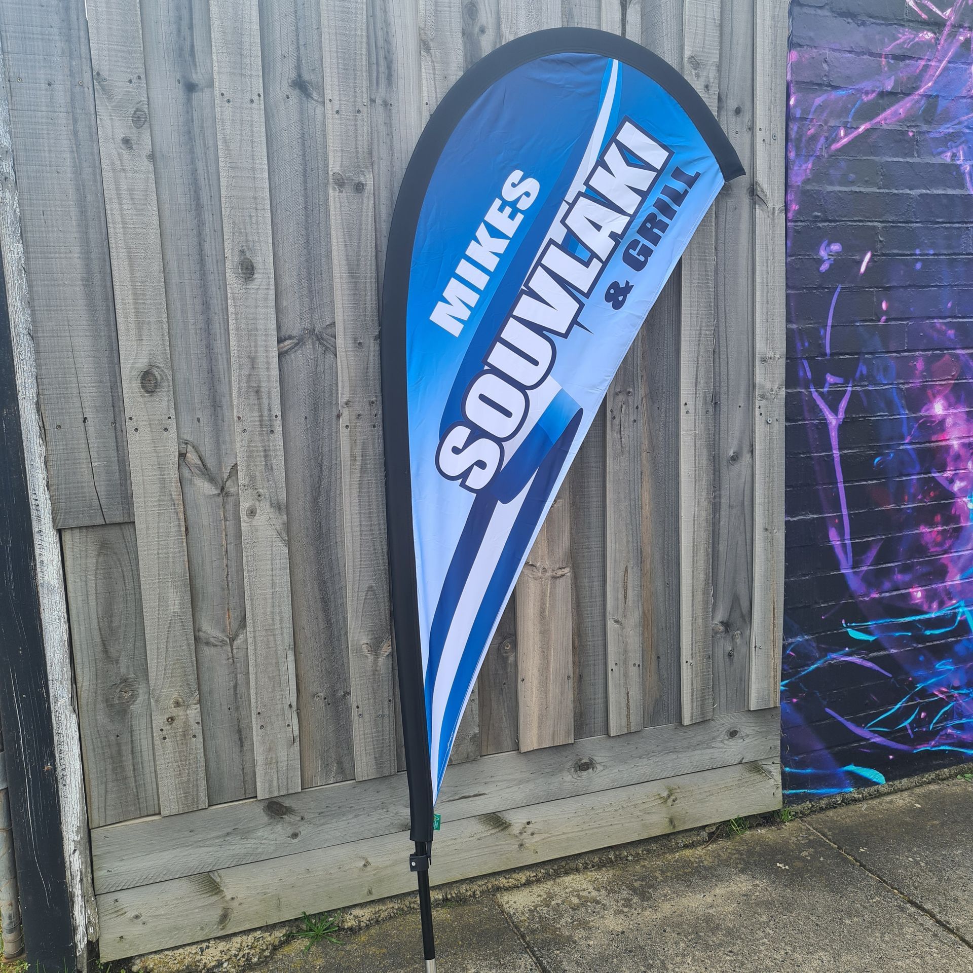 A blue and white banner for mikes souvlaki and grill