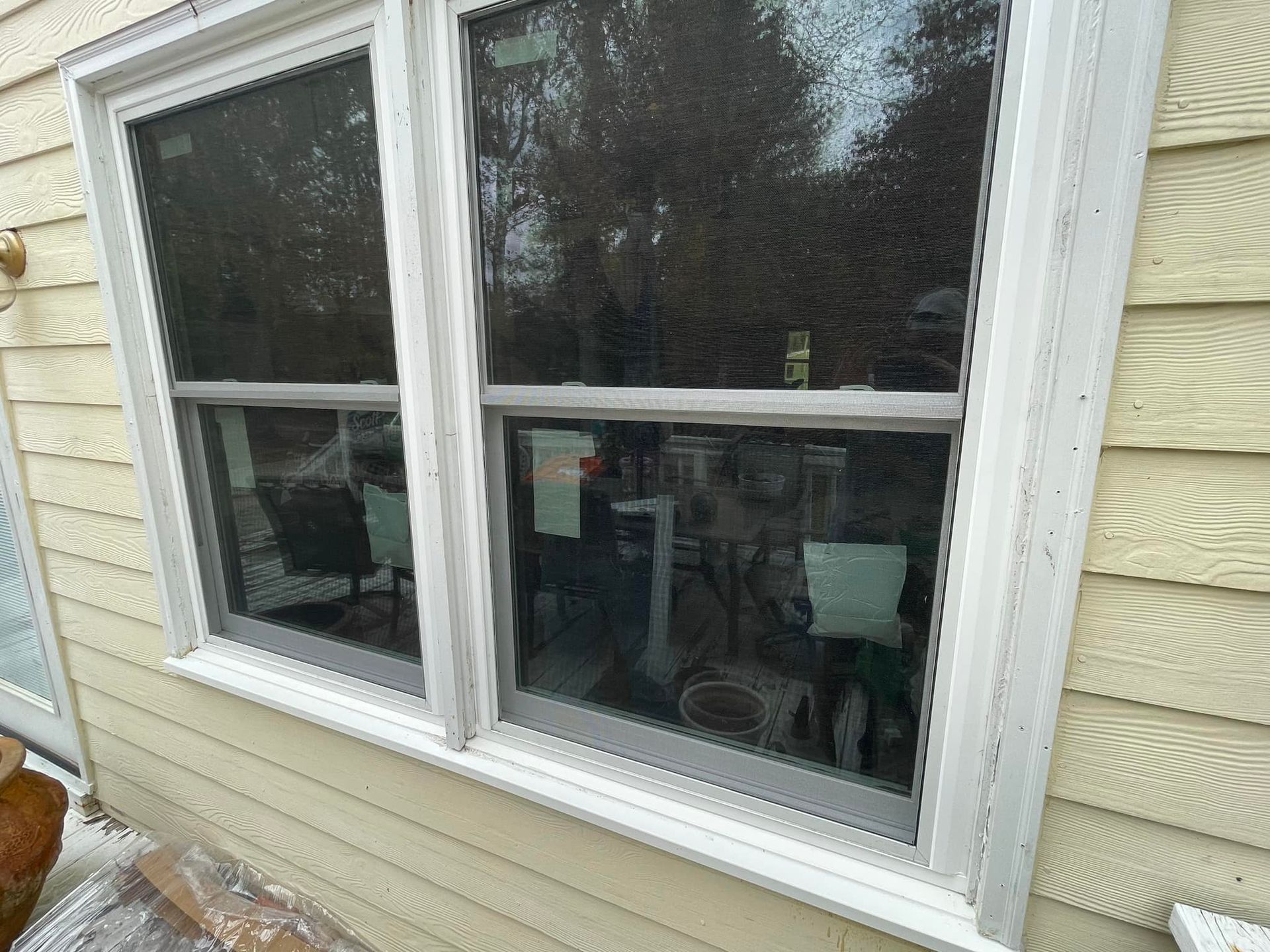 There are two windows on the side of a house.