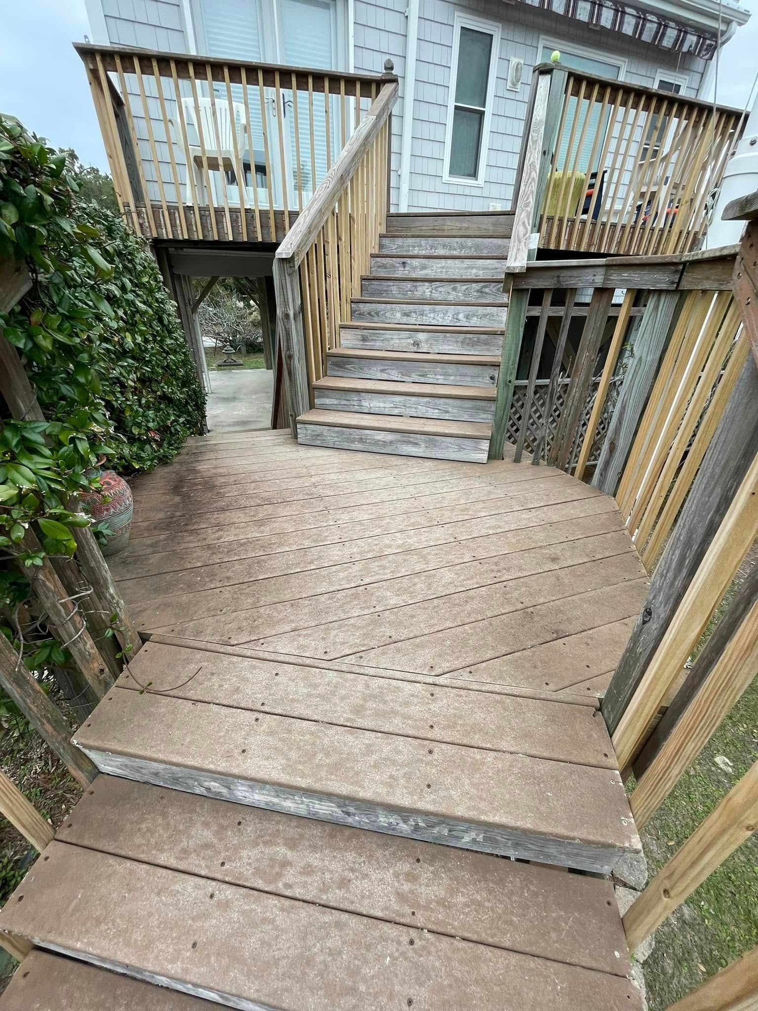 A wooden deck with stairs leading up to a house.