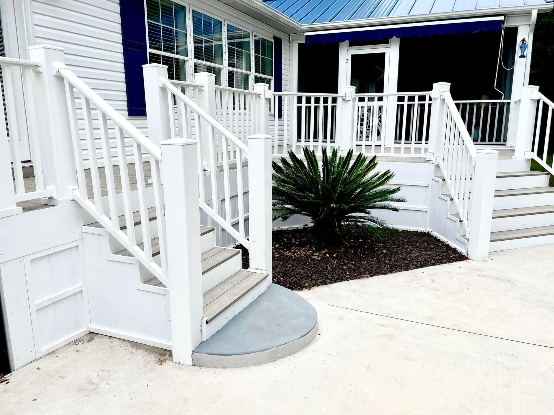 A white porch with stairs and a white railing